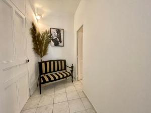 un pasillo con una silla negra y una planta en spity, en Aigues-Mortes