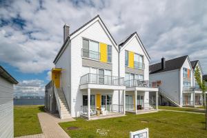 ein großes weißes Haus mit gelben Fensterläden in der Unterkunft Kleine Freiheit in Olpenitz