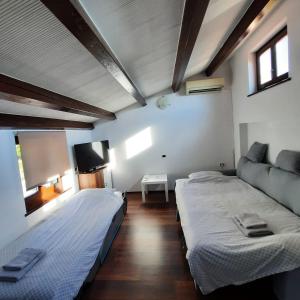 a bedroom with two beds and a flat screen tv at Apartma Rok in Plavje