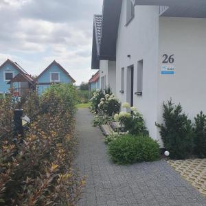 a walkway in front of a house with bushes at Domki u Marty - Władysławowo in Władysławowo