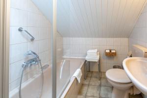 a bathroom with a shower and a toilet and a sink at Oberhausener Ferienwohnung in Oberhausen +12 photos
