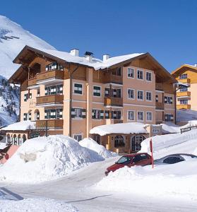 a large building with a lot of snow in front of it at Landhaus St. Georg in Obertauern