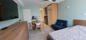 ヴィルヌーヴ・ルベにあるDream French Riviera - FAME Marina Baie des Angesのベッドルーム1室(ベッド1台、テーブル、青い椅子付)