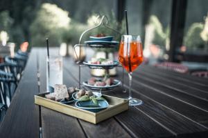 una mesa con un plato de comida y una copa de vino en Goldstück - Adults Only en Saalbach Hinterglemm