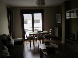 a living room with a couch and a table and chairs at Apartamento a 5 minutos de la playa in Burela de Cabo
