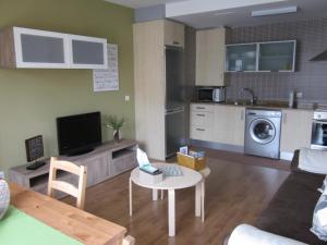 a living room with a table and a kitchen at Apartamento a 5 minutos de la playa in Burela de Cabo