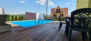 a wooden deck with a swimming pool on a house at Villa Ducic in Zlatibor