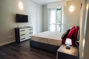 a bedroom with a bed and a dresser and a television at Residenza Vigliani in Milan