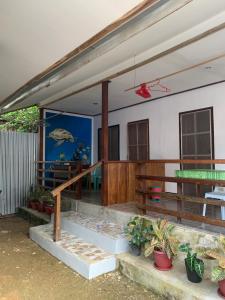 Bundal Riverside Room#1 في Itaytay: منزل مع شرفة مع نباتات الفخار