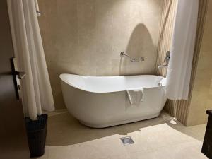 a white bath tub sitting in a bathroom at Swiss In Tabuk Hotel in Tabuk