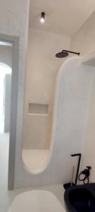 a white room with a toilet and a light at Degaetas Resort in Antiparos