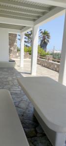 a white bench in a pavilion with a palm tree at Degaetas Resort in Antiparos