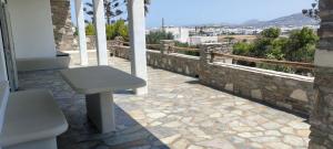a bench sitting on a patio with a stone wall at Degaetas Resort in Antiparos