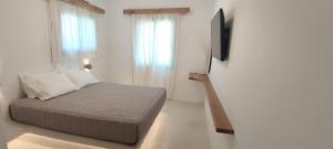a small bedroom with a bed and a television at Degaetas Resort in Antiparos