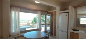 a kitchen with a table and a large window at Degaetas Resort in Antiparos