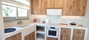 a kitchen with wooden cabinets and a sink at Degaetas Resort in Antiparos