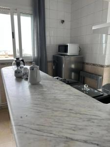 a kitchen with a marble counter top in a kitchen at Residence Mariem in Ariana