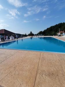 uma grande piscina azul com pessoas sentadas à sua volta em Apartman Visnja em Rudnik
