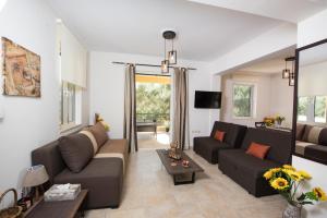 ein Wohnzimmer mit einem Sofa und einem Tisch in der Unterkunft Sol Villas in Lefkada Town