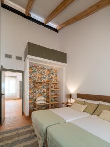 a bedroom with two beds and a mosaic wall at Apartamento para pareja, Finca Contrabando. Sanlucar del Guadiana in Sanlúcar de Guadiana