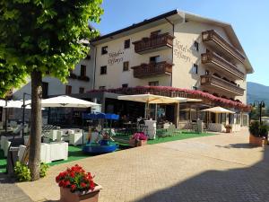 a hotel with tables and chairs and umbrellas at Hotel Tiffany's in Roccaraso