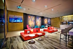 a lobby with red couches and chairs and a bar at FX INN Kaohsiung Zhonghua Road Branch in Kaohsiung