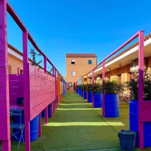 eine Reihe farbenfroher Gebäude mit Topfpflanzen darin in der Unterkunft Hôtel Acajou in Argelès-sur-Mer