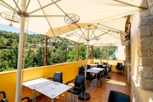 een restaurant met tafels, stoelen en parasols bij Hostal El Guerrer in Todolella