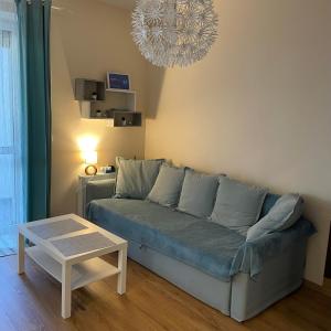 salon z kanapą i stołem w obiekcie Lux Garden Apartment w Kołobrzegu