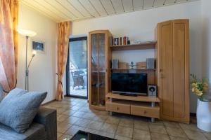 ein Wohnzimmer mit einem TV und einem Entertainment-Center in der Unterkunft Oberhausener Ferienwohnung in Oberhausen