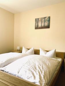 um quarto com 2 camas e lençóis brancos em Forsterhof em Pottenstein