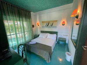 a bedroom with a white bed and a window at AH Premium Baia dei Faraglioni in Mattinata