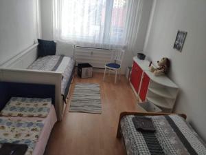 a bedroom with two beds and a desk and a teddy bear at Apartmán v centre in Kremnica