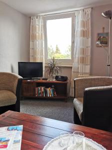 ein Wohnzimmer mit einem TV und einem Tisch in der Unterkunft Ferienhaus Appold in Wernigerode