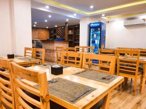 加德满都Kathmandu Aagantuk Hotel的用餐室配有木桌和椅子 更多33张照片