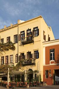 un edificio con mesas y sillas delante de él en Alcanea Boutique Hotel en La Canea