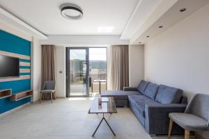 a living room with a couch and a tv at Sapphire Horizon Suites in Kissamos