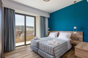um quarto com uma cama grande e uma parede azul em Sapphire Horizon Suites em Kissamos