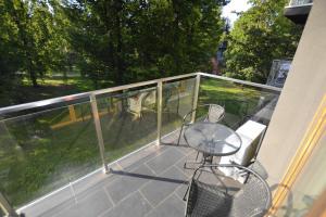 ein Balkon mit einem Glastisch und Stühlen darauf in der Unterkunft Apartament SZMARAGDOWY z garażem Centrum Gliwic-Klimatyzacja in Gliwice + 8 Fotos