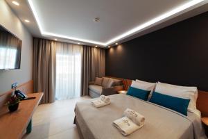 a hotel room with a large bed with towels on it at Lithos Suites - Nikiti Halkidiki in Nikiti