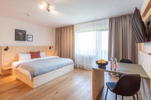 a hotel room with a bed and a desk at stuub jostal in Titisee-Neustadt