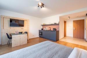 ein Schlafzimmer mit einem Bett und einem Schreibtisch sowie eine Küche in der Unterkunft stuub jostal in Titisee-Neustadt
