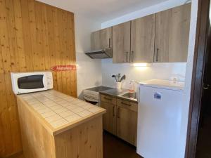 eine Küche mit einem weißen Kühlschrank und einer Mikrowelle in der Unterkunft Appartement Le Grand-Bornand, 1 pièce, 4 personnes - FR-1-241-37 in Le Grand-Bornand
