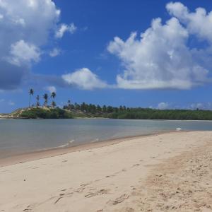 a sandy beach with palm trees on an island at Pousada Hawai in Conde