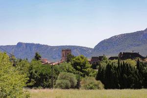 un vecchio edificio in un campo con montagne sullo sfondo di Gîte les Hirondelles a Caudiès-de-Fenouillèdes