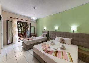 a bedroom with two beds and a balcony at Mavra Studios in Lygia
