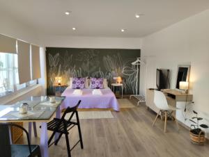 ナフプリオにあるEnallio Luxury Apartmentsのベッドルーム1室(ベッド1台、テーブル、椅子付)