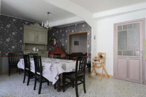 una sala da pranzo con un tavolo con sedie nere e una stanza con un tavolo di Gîte les Hirondelles a Caudiès-de-Fenouillèdes