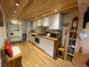 a kitchen with white cabinets and a wooden floor at Chalet Le Doux Si, Large Self-Contained Apartment, 2km from Doucy-Combelouvière and close to Valmorel in La Lechere