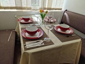 stół z talerzami i kieliszkami do wina w obiekcie Apartament Georgiana w mieście Gura Humorului